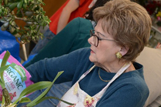 Retired woman pots plants indoors