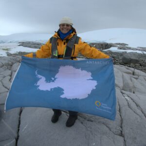 An adventurous Kendal at Ithaca resident holds the flag of Antarctica while away on a snowy expedition.