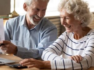 A smiling couple review their financials.